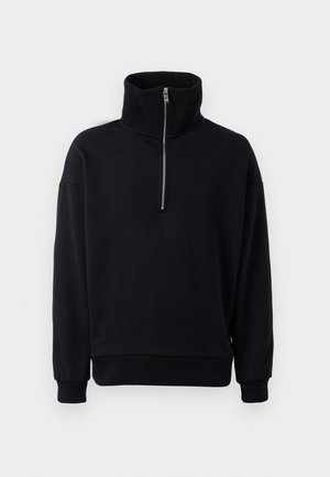 Sudadera negra de forro polar con cuello alto y cremallera de media longitud. Presenta puños y dobladillo inferior acanalados, exhibiendo una textura suave y lisa.
