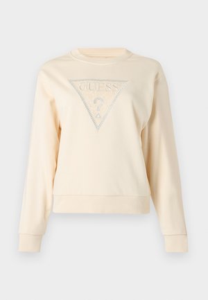 Lys beige genser med lange ermer, rund hals og en trekantet logo med ordet "GUESS" og et dekorativt spørsmålstegn design.