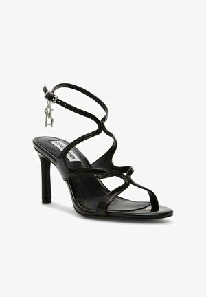 Sandalo con tacco alto in pelle verniciata nera, con cinturini incrociati, punta aperta e cinturino alla caviglia regolabile con un accento in hardware argentato.