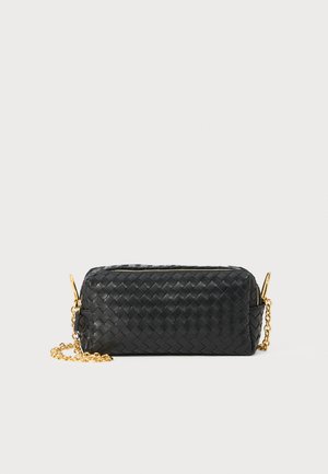 Black woven leather rectangular clutch with gold chain strap and top zipper against a white background.