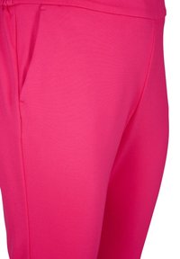Fuchsia joggers lavet af blødt, strækbart materiale, med en sidelomme og elastisk talje, tætsiddende snit med glat tekstur.