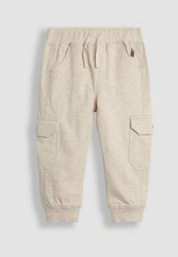 Ljust beige joggerbyxor tillverkade av mjukt tyg, med elastisk midja, snörning och två sidofickor.