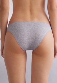 Szare bawełniane majtki bikini o gładkiej fakturze, niskim stanie i minimalnym pokryciu. Posiadają miękką elastyczną talię oraz smukły kształt.