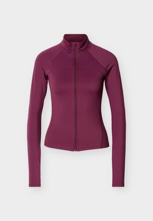 Pikad varrukad, vormitav, sügavlilla lukkjakiga jakk, kõrge krae ja nähtavate õmblustega varrukatel ja rinnal.