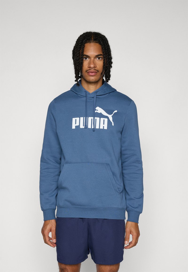 Blauer Hoodie aus weichem Material, mit einem großen weißen "PUMA"-Logo und einer Kängurutasche, mit Kapuze mit Kordelzug und gerippten Bündchen.