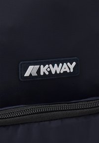 Tessuto di un blu navy scuro con una texture liscia presenta un logo K-WAY bianco, posizionato sopra una chiusura con zip per l'accesso.