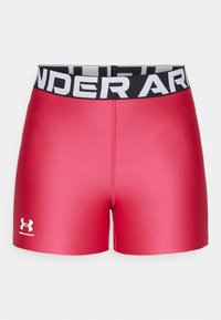 Červené sportovní šortky z hladkého, elastického materiálu. Mají černý elastický pás s nápisem "UNDER ARMOUR" v bílé barvě.
