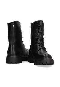 Botas de combate de cuero negro con cordones en la parte delantera, cremallera lateral y suelas de goma gruesa con dibujo para mayor tracción.