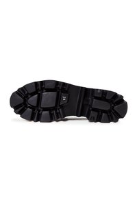Semelle de chaussure noire robuste avec des crampons profonds et une indication de taille "36", conçue pour l'adhérence et la durabilité.