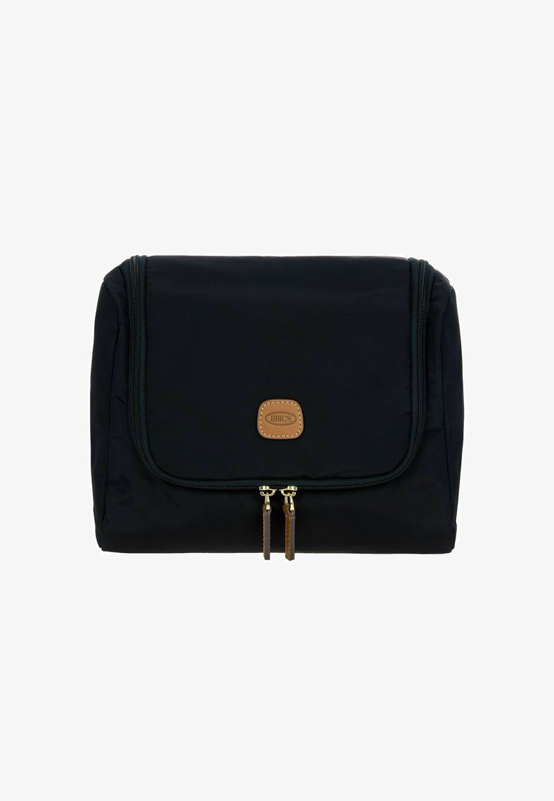 Sac de voyage en tissu noir avec une fermeture à rabat, doté d'un patch logo en cuir brun et de deux zips dorés avec des accents marron.