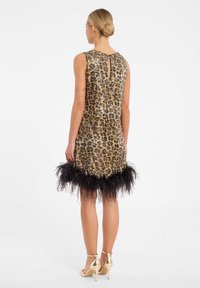 Robe imprimée léopard avec des sequins dorés, design sans manches, ourlet en plumes noires, détail en goutte d'eau au dos, accompagnée de talons dorés.