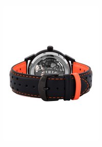 Schwarzes Lederarmband mit orangefarbenen Akzenten und Perforationen. Klare Gehäuserückseite zeigt komplexe Mechaniken. Runde schwarze Zifferblatt mit Knopf.