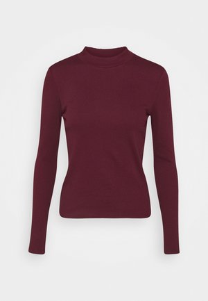 Pull à col roulé bordeaux à manches longues et coupe ajustée, avec un col côtelé et un tissu en maille douce, présenté sur un fond blanc.