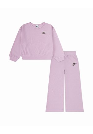 Ensemble composé d'un haut en maille gaufrée lilas Nike à manches longues et col ras du cou, et d'un pantalon à jambes larges, avec des logos Nike noirs sur la poitrine et la cuisse gauche.