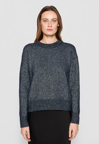 Maglione lavorato a maglia blu navy con una vestibilità leggermente ampia, scollatura rotonda e polsini e orlo a coste. Presenta un tessuto morbido e testurizzato con una leggera lucentezza.