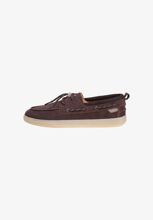 Zapato náutico de ante marrón con cordones delanteros, suela ligera de goma, interior de malla y una etiqueta "Since 1973" en el lateral.