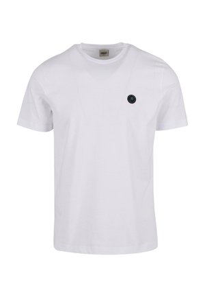 Fehér pamut póló rövid ujjakkal, kerek nyakkivágással, és egy kis fekete kör alakú logóval a bal mellkasán.