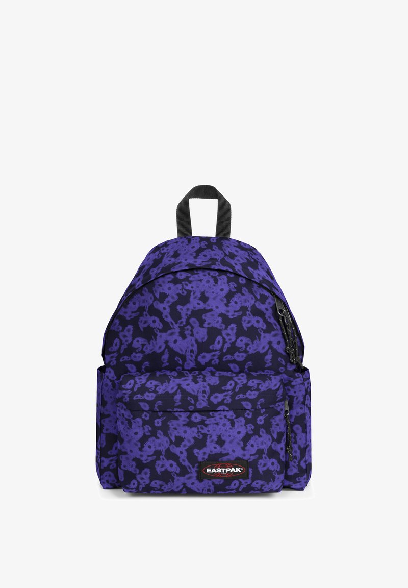 Sac à dos violet avec motif floral, doté d'une poignée supérieure, de bretelles ajustables et d'une poche zippée avant. Étiquette de la marque visible à l'avant.