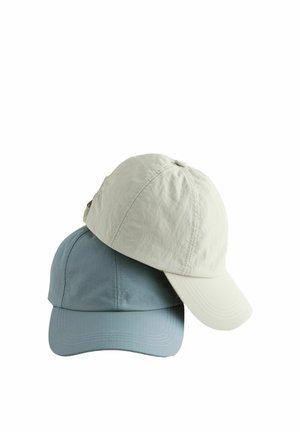 Two plain baseball caps stacked, one light beige on top and one muted blue beneath, displayed on a white background.