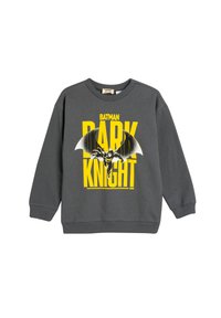 Sudadera gris con un gráfico de Batman en negro y amarillo. El diseño incluye un texto en negrita que dice "CABALLERO OSCURO". Puños y dobladillo acanalados.