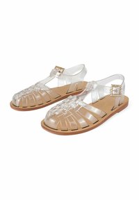 Sandali in plastica trasparente con un design a strisce, open toe, e suola marrone. Presentano una fibbia in tono oro per la chiusura.