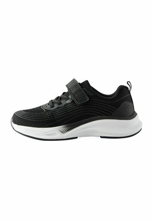 Chaussure de sport noire avec une tige texturée, semelle blanche et sangle velcro. Caractéristiques d'un design épuré avec de subtils motifs linéaires le long des côtés.