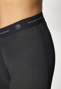 Schwarze Fahrradshorts aus strukturiertem Stoff, elastischer Bund mit dem Markennamen "ENDURA" in Grau. Entwickelt für Komfort und Leistung.
