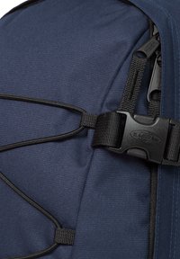 Mochila de marina con tejido duradero, superficie texturizada, herrajes en negro, correas ajustables y un mecanismo de cierre seguro con hebilla.