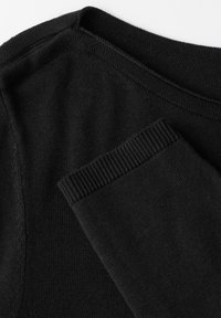 Schwarzer Strickpullover mit rundem Halsausschnitt, verfügt über ribbelte Bündchen und eine weiche, glatte Textur. Der Stoff ist gleichmäßig in Farbe und Konsistenz.