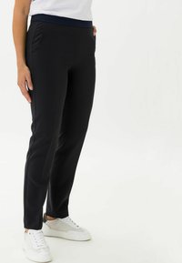 Zwarte op maat gemaakte broek met een marineblauwe elastische tailleband, voorzien van zijzakken en een slim-fit ontwerp, gemaakt van gladde, elastische stof.