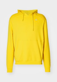 Sweat à capuche jaune vif avec manches longues, capuche à cordon, poche kangourou et petit logo réfléchissant sur la poitrine.