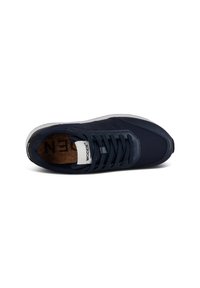 Zapatilla de color azul marino con parte superior de malla y sintético, cierre de cordones plano, plantilla de corcho y suela de goma blanca. Cuenta con una etiqueta de logo.