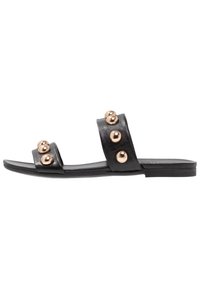Black leather slide sandals with two wide straps adorned with metallic gold spheres, featuring a flat sole and minimalistic design.