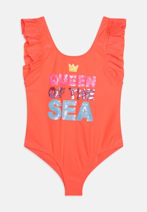Maillot de bain une pièce corail avec des accents de volants aux épaules, arborant un texte pailleté "REINE DES MERS" dans différentes couleurs et une couronne au-dessus.