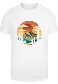 White t-shirt featuring a circular graphic of mountains, orange sun, clouds, and green pine trees, illustrating a nature scene.