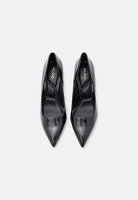 Escarpins en cuir noir à bout pointu avec une finition brillante, présentant un design élégant et une semelle intérieure rembourrée. Logo ALDO visible à l'intérieur.