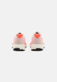 Scarpe da ginnastica rosa con tomaia in mesh, accenti arancioni a contrasto, suola ammortizzata e battistrada nero resistente. Vista posteriore che mostra i dettagli del design.