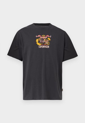 Svart T-skjorte med korte ermer, med et fargerikt våpenskjolddesign og teksten "Velvet Store Seal of Approval Copenhagen" på brystet.