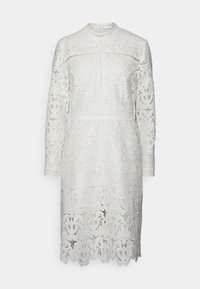 Bílé krajkové šaty s dlouhými rukávy, vysokým límcem, složitými květinovými vzory, vlnkovým lemem a zapínáním na zadní klíčovou dírku.