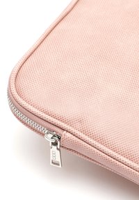 Housse d'ordinateur portable rose texturée avec une finition lisse, équipée d'une fermeture éclair argentée et d'une languette rectangulaire. Les coins arrondis améliorent la forme.