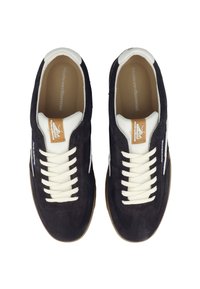 Marina mockasiner i mocka med vita läderdetaljer, vita snörningar och en gummisula. Har en brun logotypklistermärke på tungan och kontrasterande sömmar.