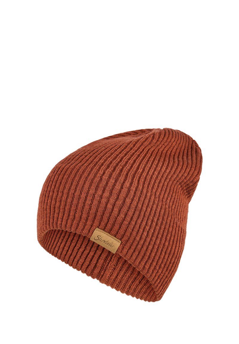 Ribbed beanie in burnt orange, made of soft fabric. Features a fold-over cuff and a small stitched logo tag on the side.