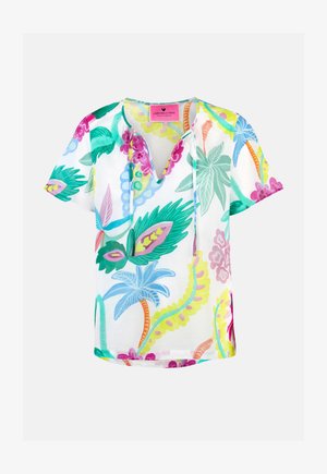 White short-sleeve blouse with colorful tropical floral print, V-neck with ties, and a pink brand label inside the collar.