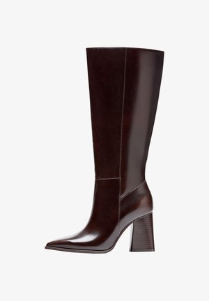 Korkean varren ruskeat nahkasaappaat, joissa on terävä kärki ja teksturoitu jalkapohja. Ominaisuuksiin kuuluu selkeä muotoilu ja vähäiset ompeleet.