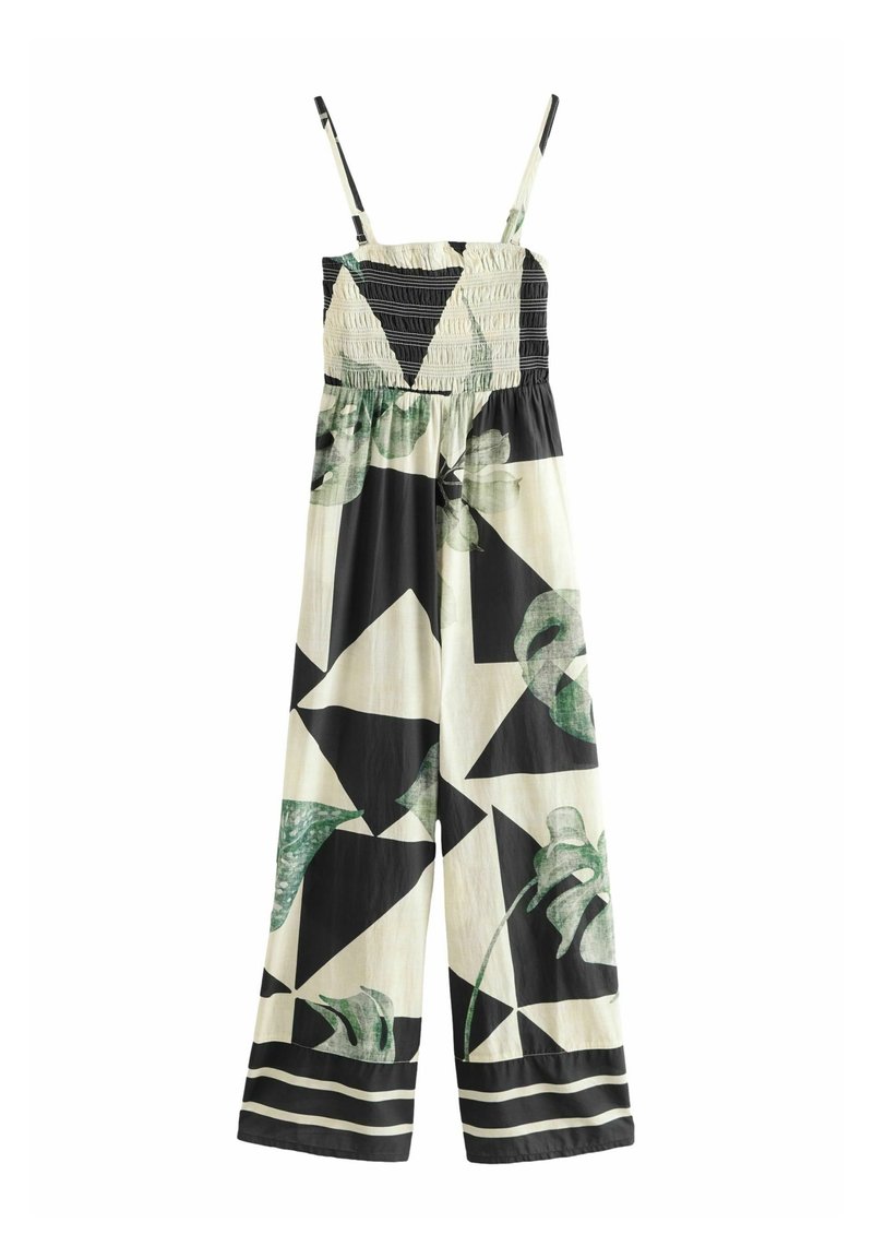 Combinaison sans manches avec fines bretelles, haut froncé noir et blanc, jambes larges avec formes géométriques noires et motifs feuillages verts.