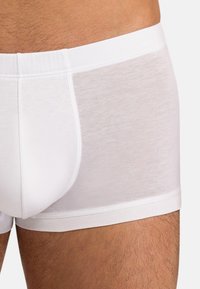 Weiße Boxer-Unterwäsche aus weicher Baumwolle, mit einem glatten Bund und einem enganliegenden Design sowie einem leicht durchsichtigen Rückenteil.