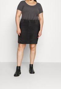Schwarzer Jeansrock mit geradem Schnitt, ausgestattet mit einem Bund, vorderen Taschen und dezenten Steppnähten. Kombiniert mit einem grauen, taillierten T-Shirt und schwarzen Stiefeln.