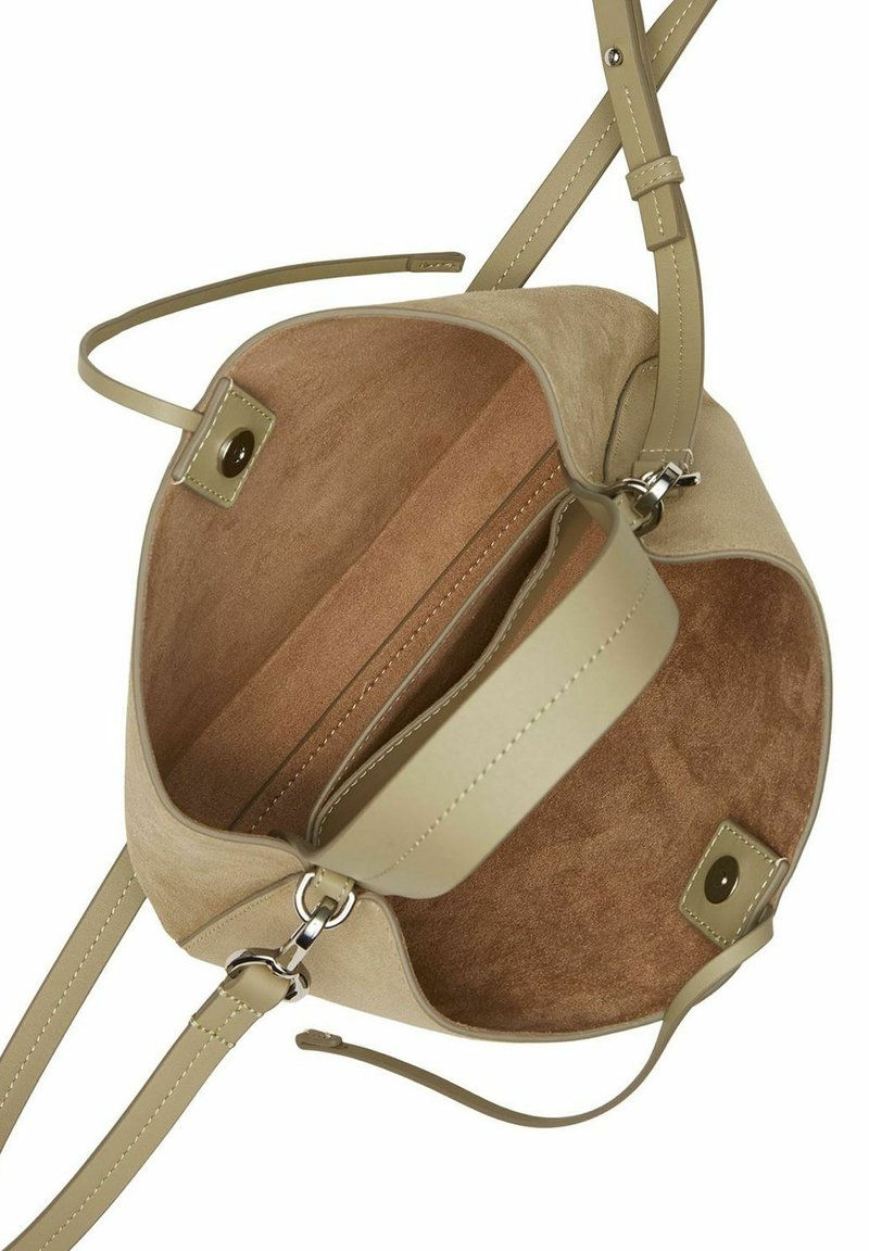 Beige Wildleder-Handtasche mit einer glatten Innenauskleidung, verstellbarem Tragegurt und einem einzelnen Reißverschlussfach. Magnetverschluss an der Oberseite.