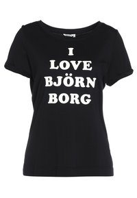 Camiseta de manga corta negra con cuello redondo que presenta un texto blanco que dice "YO AMO BJÖRN BORG" en una fuente audaz y juguetona. Material de algodón suave.