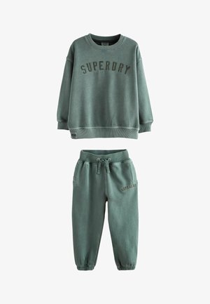 Grøn bomulds sweatshirt og matchende joggersæt. Sweatshirten har teksten "SUPERDRY", rund hals og ribbede mansjetter. Joggerne har en elastisk talje.